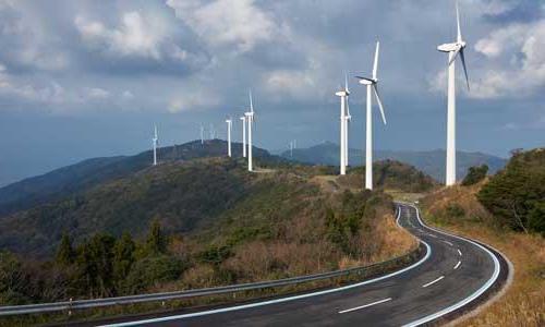 A road winding through wind turbines